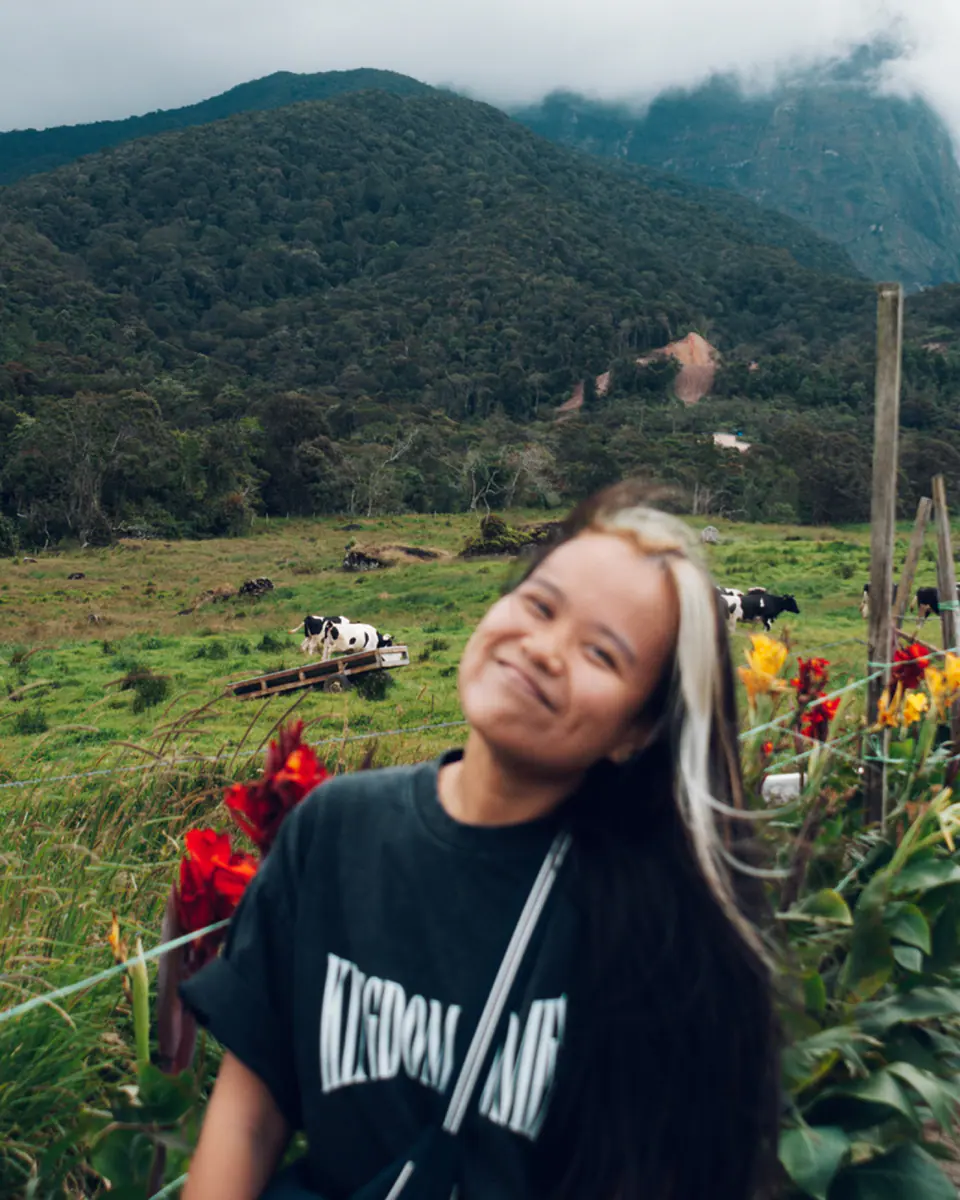 Deborah Chin, smiling, in a flower-filled highland meadow